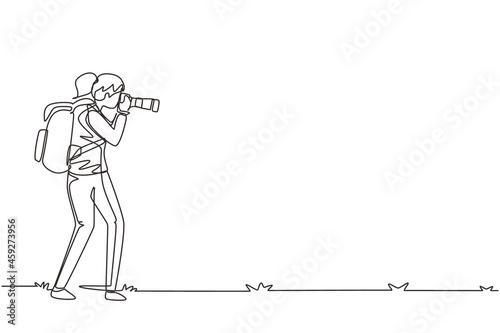 Single one line drawing female photographer standing and taking photo using camera, tourist with backpack. Photographer with her telephoto lens. Continuous line draw design graphic vector illustration