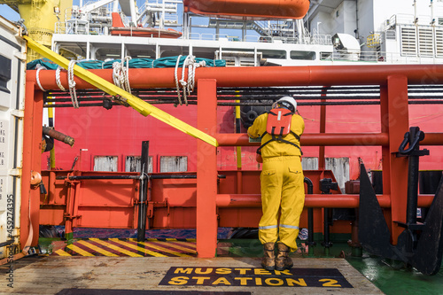 An offshore construction supervisor leaning on the railing while waiting to transfer from a boat to a construction work barge at offshore oil field.