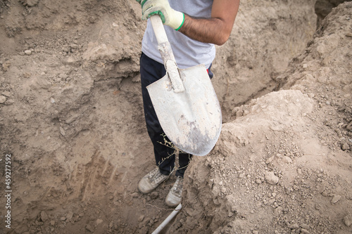 Caucasian worker digging a hole.