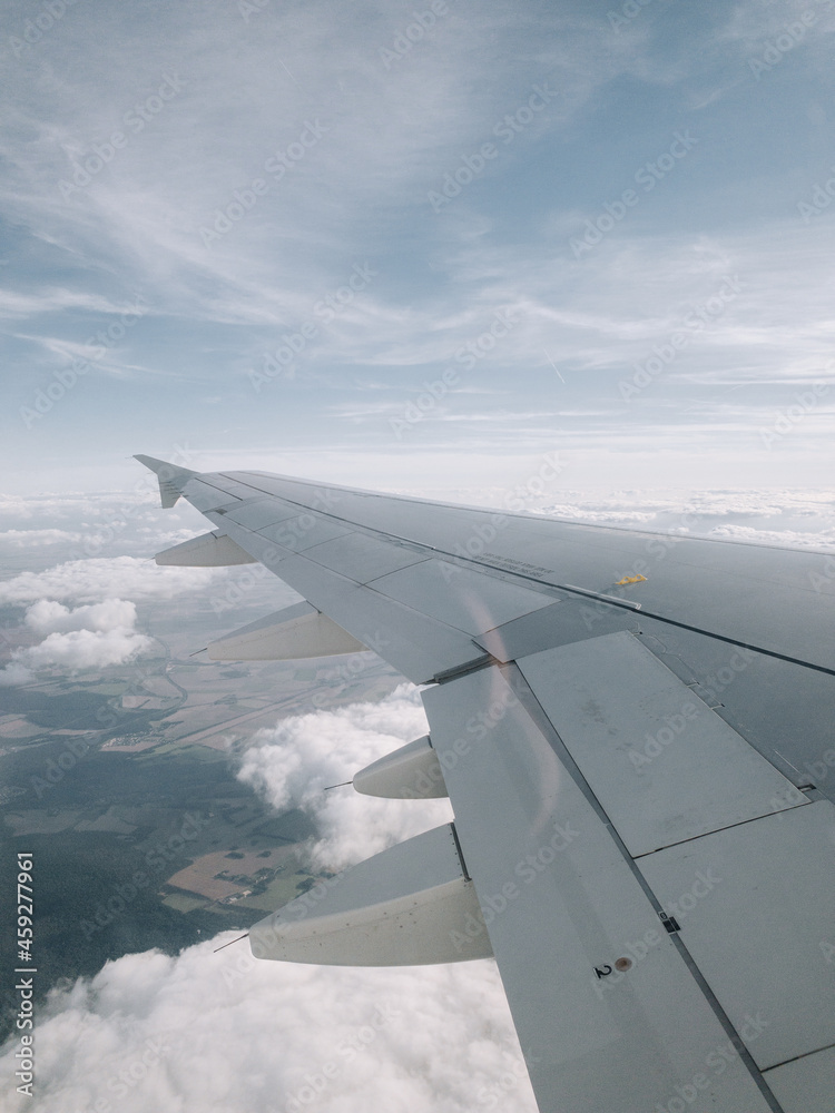 Wing of a plane flying over the clouds