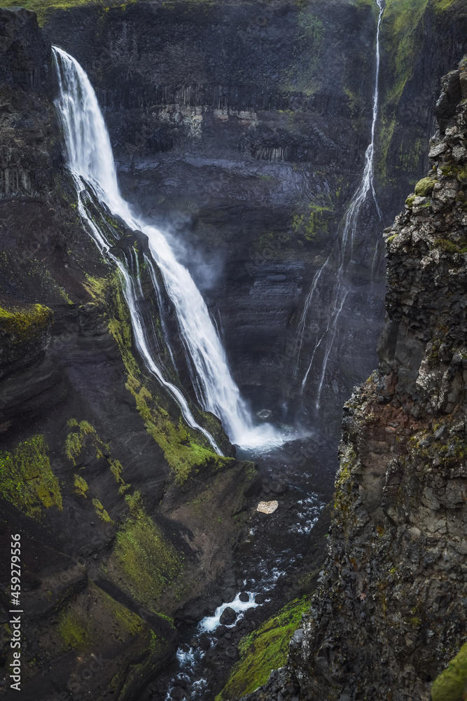 Haifoss waterfall in South Iceland in the dusk. Beautiful nature dramatic moody landscape. Vertical view