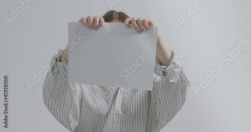 Girl tears a sheet of paper on a white background. Girl aggression due to bullying.