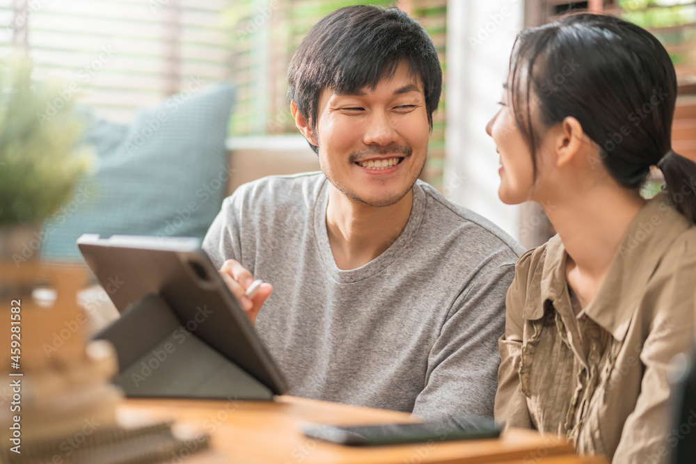 home isolate quarantine,asian and lover marry couple sit relax using laptop and tablet working from home or shopping online surfing social media with cheerful in living room home interior background home isolate quarantine,asian and lover marry couple sit relax using laptop and tablet working from home or shopping online surfing social media with cheerful in living room home interior background