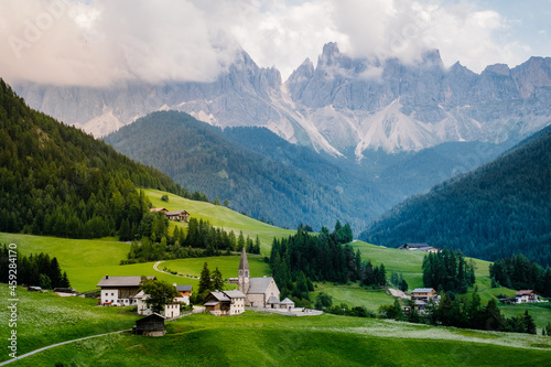 Santa Magdalena village in Val di Funes on the italian Dolomites. Autumnal view of the valley with colorful trees and Odle mountain group on the background. Italy Europe photo