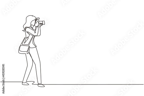 Single continuous line drawing woman photographer holding photo camera and photographing. Creative profession or occupation. Happy female take photo shot. One line draw design vector illustration