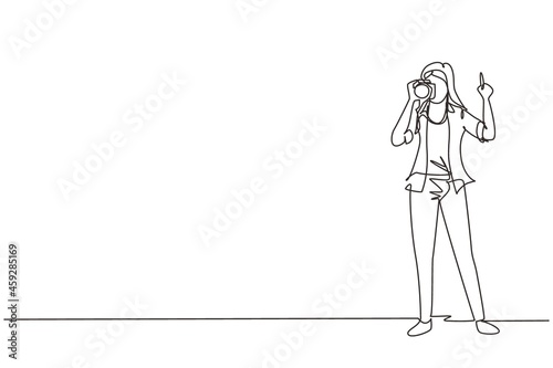 Continuous one line drawing woman photographer using professional camera in the studio. Female standing and giving count gesturing for taking pictures. Single line draw design vector illustration
