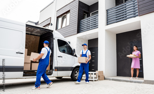 Photography Two removal company workers are loading boxes into a minibus.