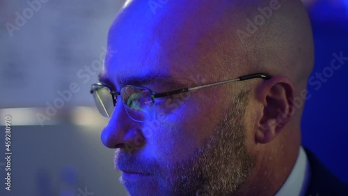 Close up of man using computer with refelction of code in his glases photo