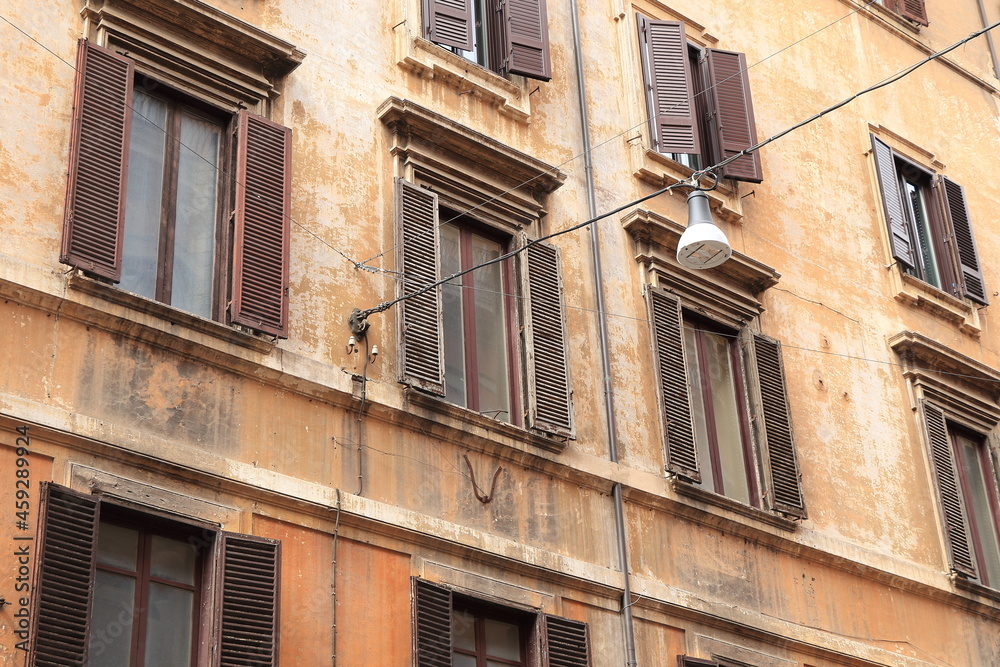 Rome Via del Corso Street Close Up with Typical Brown House Facades with Shutters and Hanging Street Light, Italy