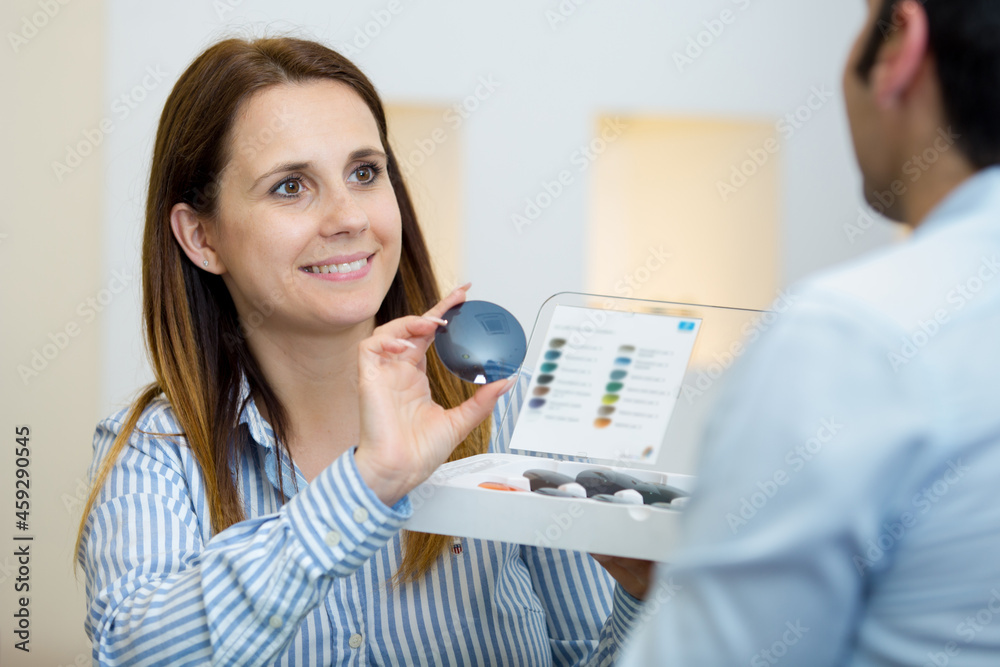 female optician offering glasses to positive man female optician offering glasses to positive man