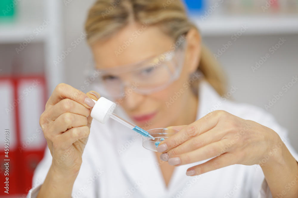 senior woman working with pipettes in a lab senior woman working with pipettes in a lab