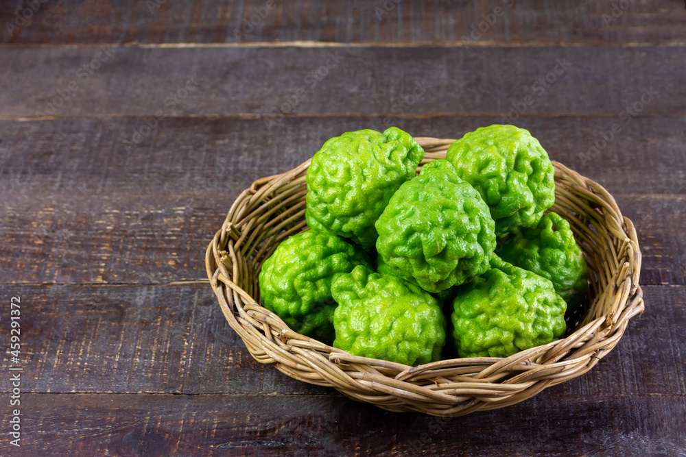 Bergamot fruit in wicker basket on wooden table. Bergamot is ingredient in asean food and is herb for body care. Bergamot fruit in wicker basket on wooden table. Bergamot is ingredient in asean food and is herb for body care.