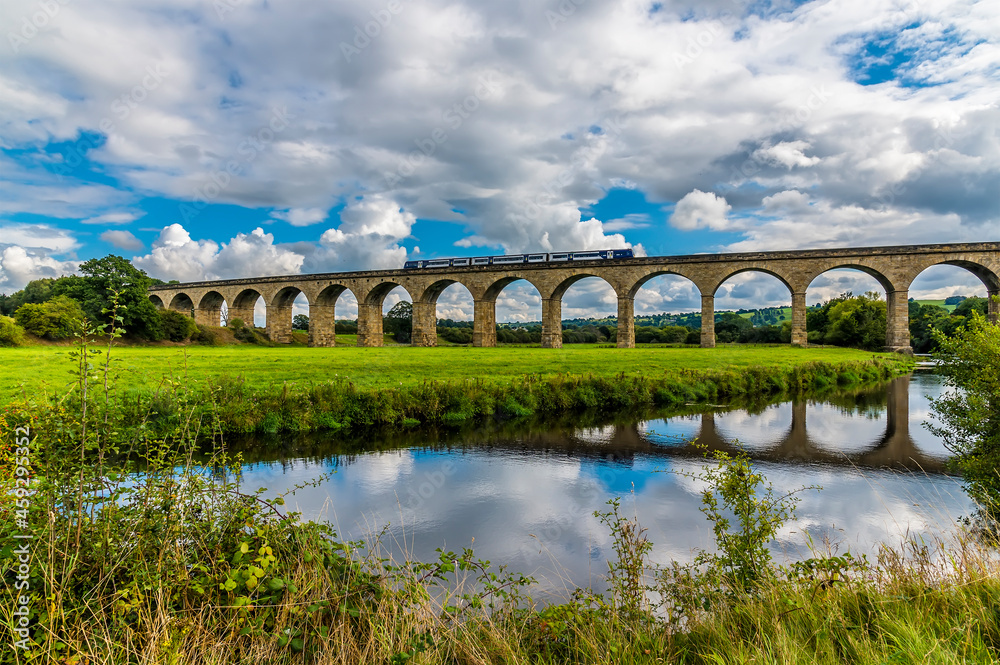 A view of a train crossing the Arthington Viaduct in Yorkshire, UK in summertime