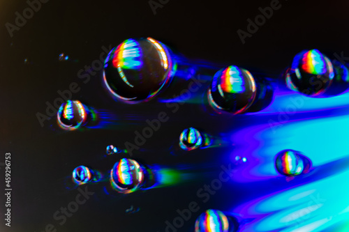 Krople wody na płycie CD refleksy świetlne kolorowe ciemne