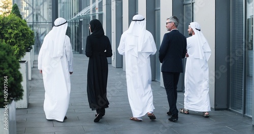 Photography Full length view of the multi-ethnic group of business people are walking outdoors in city street talking with each other on sunny summer day