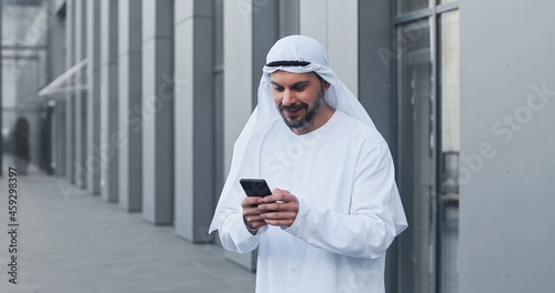 Tableau sur toile Waist up portrait view of the arabian businessman wearing kandora looking at his