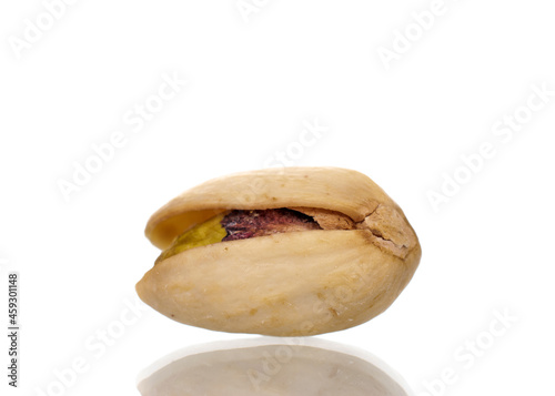 One unpeeled pistachio, close-up, isolated on white.