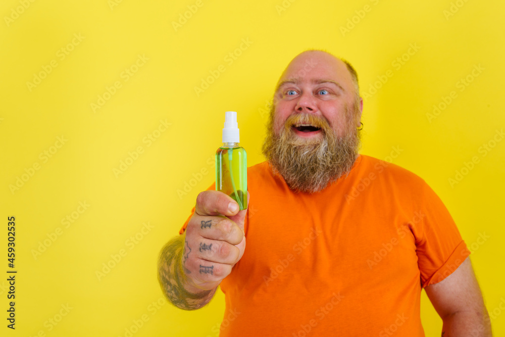 Happy man with beard and tattoos holds a hands cleaner against covid19 Happy man with beard and tattoos holds a hands cleaner against covid19