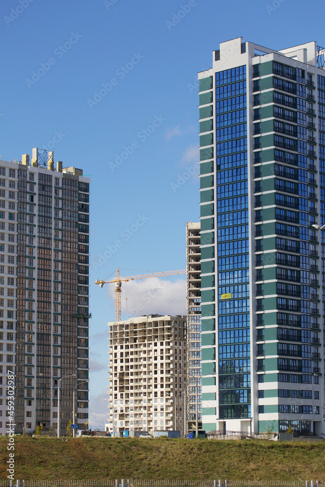 Construction of modern multi-storey buildings. Construction of a new city block. Buildings under construction and tower cranes.