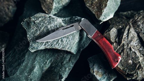 Pocket knife on stone background photo