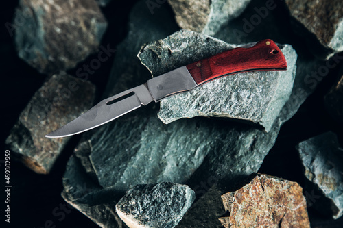 Pocket knife on stone background photo