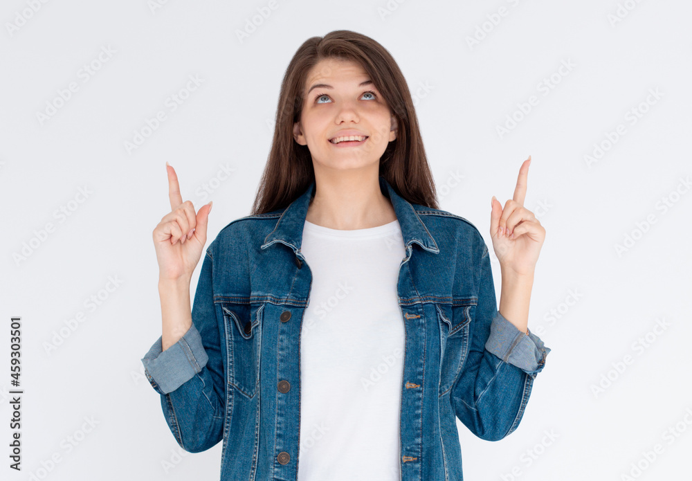 Pretty young brunette in jeans shirt gesturing up with fingers Pretty young brunette in jeans shirt gesturing up with fingers