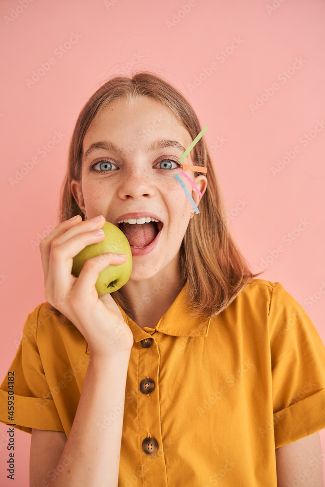 Little girl with stickers on her face eating apple Little girl with stickers on her face eating apple