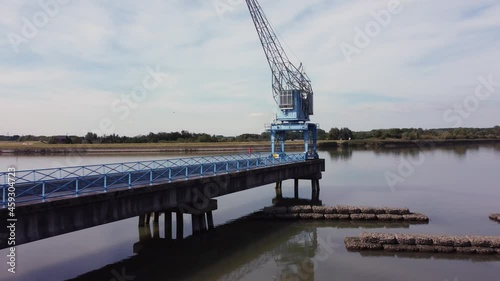 Blue old abandoned industrial crane at river Hollandse IJssel in the Netherlands, aerial flying towards the crane photo