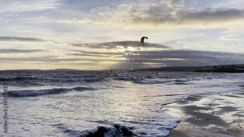 Kitesurfers and waves in sunset over Atlantic
