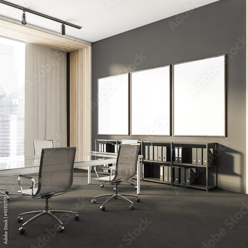 Corner view on dark office interior with three white posters