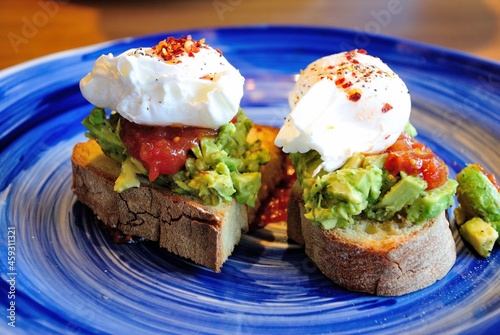 Avocado toast with poached eggs and salsa sauce, served in Newcastle, UK photo