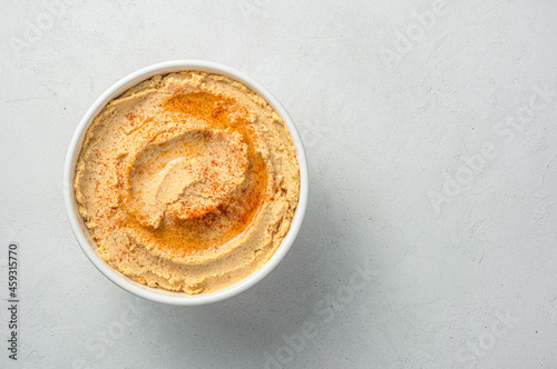 Traditional hummus flavored with olive oil and paprika on a gray background. Oriental  healthy food.