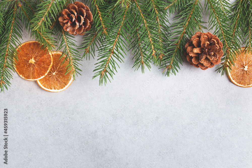 Winter natural decor on grey background. Spruce branch, pine cones and dry orange. Flat lay, top view, copy space. Winter natural decor on grey background. Spruce branch, pine cones and dry orange. Flat lay, top view, copy space.