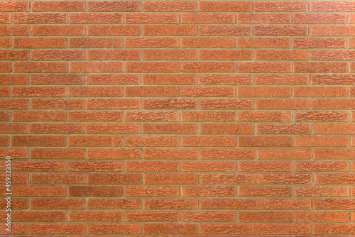 Terracotta colored brick wall with grey mortar.