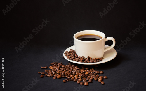 Coffee cup and coffee beans on dark background