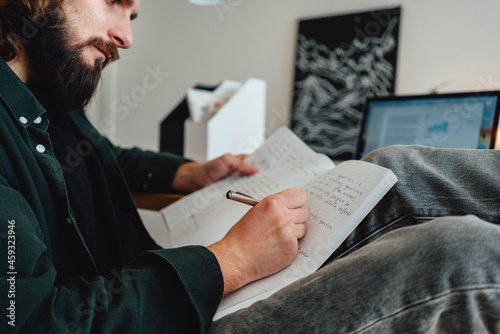 Online student prepare for pass exam to university using laptop while sit at home. Pensive bearded student at college making universitet subjects