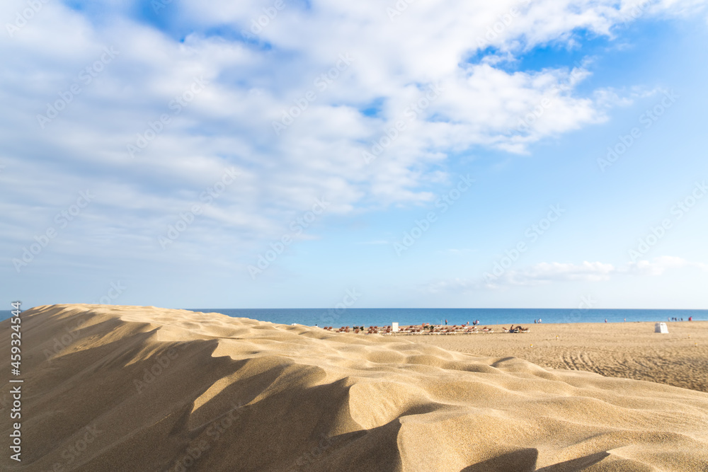 Naklejka premium Sea coast. Sand dunes. People on the horizon.