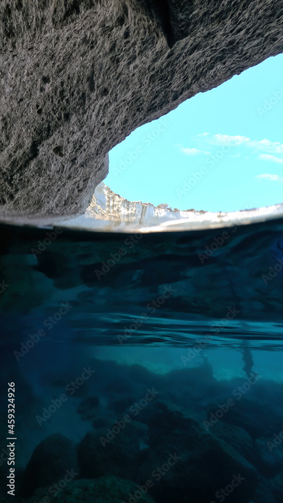 Underwater split photo of beautiful paradise volcanic white rock famous Kleftiko with emerald crystal clear sea and caves, Milos island, Cyclades, Greece