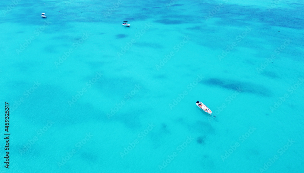 Top view of the gorgeous emerald clear ocean water in the Seychelles. Boats on the water