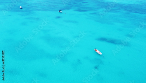 Top view of the gorgeous emerald clear ocean water in the Seychelles. Boats on the water © Payllik