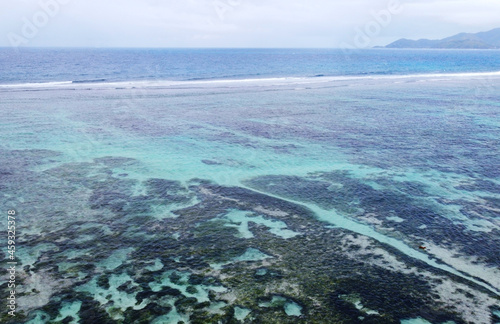 Top view of a beautiful emerald beach with corals in the Seychelles