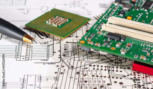 Fotografija Electronic board and processor lie on background of schematic circuit diagramm and photomask for the manufacture of printed circuit boards