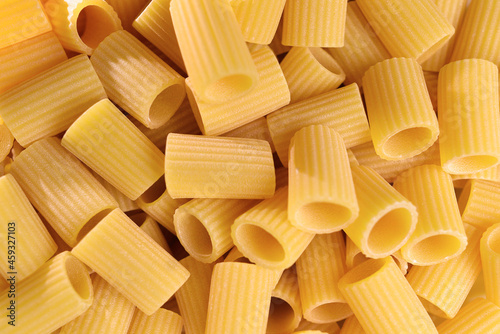Italian Macaroni Pasta half sleeves striped raw food background or texture close up. Closeup of traditional raw italian pasta.