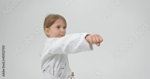 The girl is turned to the side and performs hand strikes. Hands bent into a fist. Hit the girl's hand right in front of you.