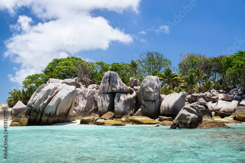 Coastal smooth boulders on the large background of island.
