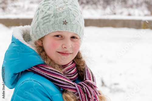 Portrait of the girl  in the winter.The girl against the background of snow. Winter scene. © O.PASH