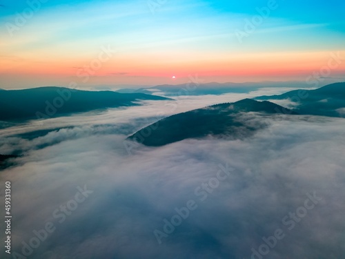 Fog in the mountain valley at dawn. Ukrainian Carpathians in the morning in the haze. Aerial drone view. © Sergey