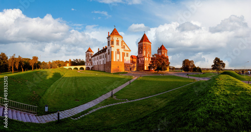 Mir Castle in Belarus at sunset with a blue sky and clouds.Landscape of an old castle against beautiful sky with white clouds on sunset.