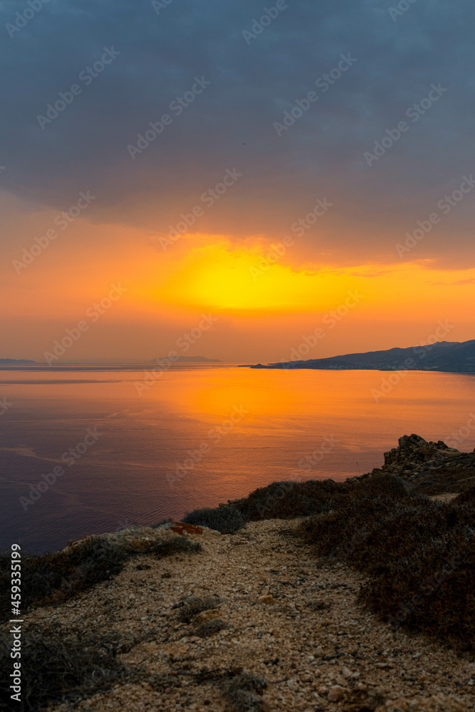 Coastline View of Sun Peaking Through Clouds in Mykonos Greece