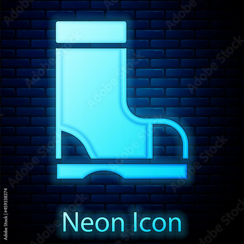 Glowing neon Waterproof rubber boot icon isolated on brick wall background. Gumboots for rainy weather, fishing, gardening. Vector